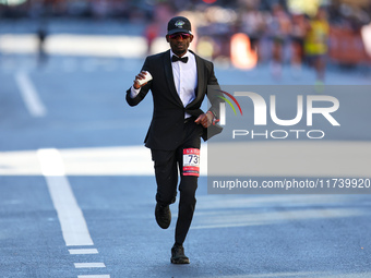 Hakeem Olajuwan Adewale of Germany heads up First Avenue in a suit during the 2024 New York City Marathon in New York, N.Y., on November 3,...