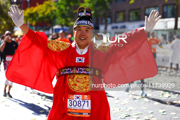 Ju Hyun Kim of South Korea, known as ''The Running King,'' raises his arms in the air as he heads up First Avenue during the 2024 New York C...