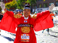 Ju Hyun Kim of South Korea, known as ''The Running King,'' raises his arms in the air as he heads up First Avenue during the 2024 New York C...