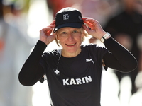 Karin Stoop of Switzerland puts her cap back on after dousing herself as she heads up First Avenue during the 2024 New York City Marathon in...