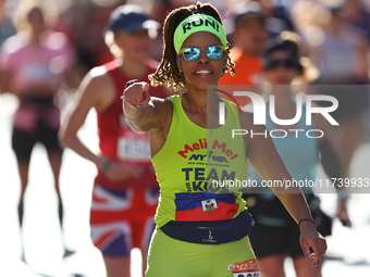 Melissa Mondesir of the United States gestures towards the camera as she heads up First Avenue during the 2024 New York City Marathon in New...