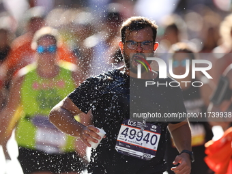 Runner Pedro Girundi of Brazil receives some needed relief after dousing himself with water while running up First Avenue during the 2024 Ne...