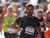 Runner Pedro Girundi of Brazil receives some needed relief after dousing himself with water while running up First Avenue during the 2024 Ne...