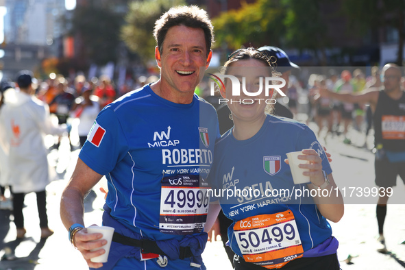 Roberto and Sofia Cere of Italy pose for a photo at mile 16 as they head up First Avenue during the New York City Marathon in New York, N.Y....