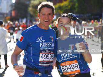 Roberto and Sofia Cere of Italy pose for a photo at mile 16 as they head up First Avenue during the New York City Marathon in New York, N.Y....