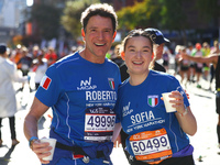 Roberto and Sofia Cere of Italy pose for a photo at mile 16 as they head up First Avenue during the New York City Marathon in New York, N.Y....