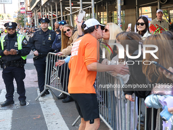 A runner stops to kiss his wife who watches him race during the New York City Marathon in New York City, United States, on November 3, 2024....