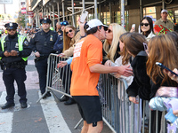 A runner stops to kiss his wife who watches him race during the New York City Marathon in New York City, United States, on November 3, 2024....