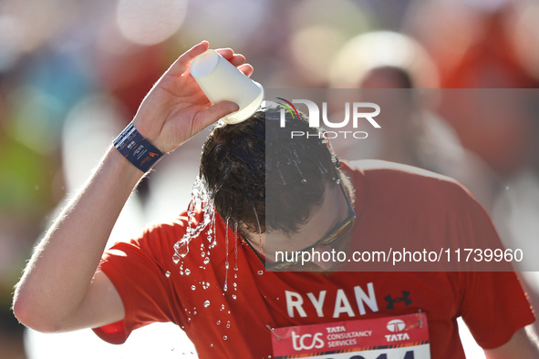 Ryan Holgers of the United States receives some needed relief after dousing himself with water while running up First Avenue during the 2024...