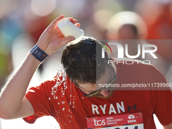 Ryan Holgers of the United States receives some needed relief after dousing himself with water while running up First Avenue during the 2024...