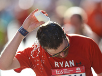 Ryan Holgers of the United States receives some needed relief after dousing himself with water while running up First Avenue during the 2024...