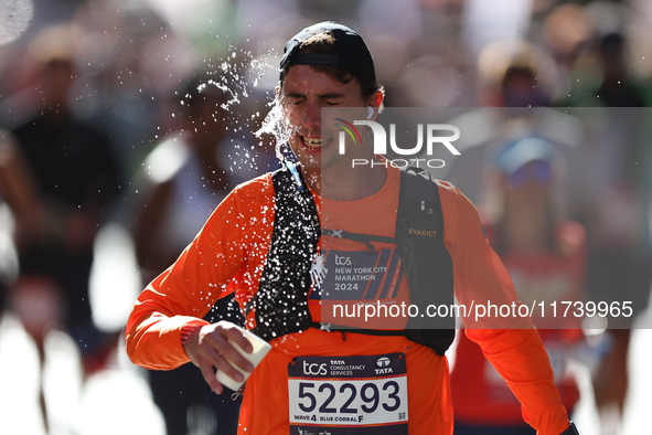 Runner Tony Frbezar of France douses himself with water while running up First Avenue during the 2024 New York City Marathon in New York, N....