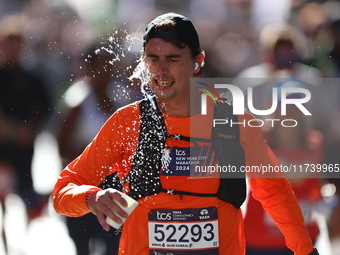 Runner Tony Frbezar of France douses himself with water while running up First Avenue during the 2024 New York City Marathon in New York, N....