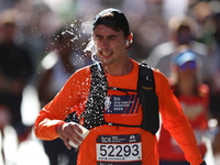 Runner Tony Frbezar of France douses himself with water while running up First Avenue during the 2024 New York City Marathon in New York, N....