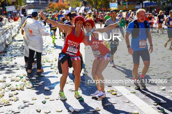 Runners Michelle Douglas and Michelle Richards of the United States pose for a photo as they head up First Avenue during the 2024 New York C...