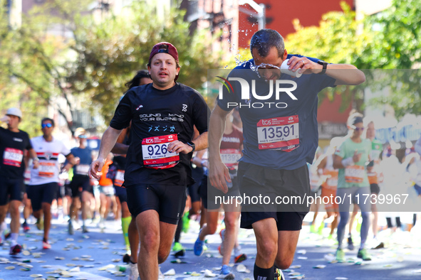 A runner receives some needed relief after dousing himself with water while running up First Avenue during the 2024 New York City Marathon i...