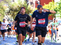 A runner receives some needed relief after dousing himself with water while running up First Avenue during the 2024 New York City Marathon i...