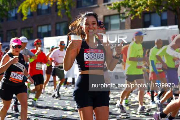 Runner Yejin You of South Korea gives a thumbs up as she heads up First Avenue during the 2024 New York City Marathon in New York, N.Y., on...