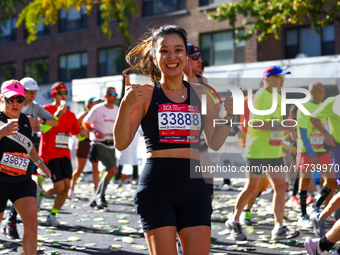 Runner Yejin You of South Korea gives a thumbs up as she heads up First Avenue during the 2024 New York City Marathon in New York, N.Y., on...