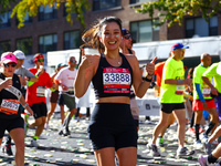 Runner Yejin You of South Korea gives a thumbs up as she heads up First Avenue during the 2024 New York City Marathon in New York, N.Y., on...