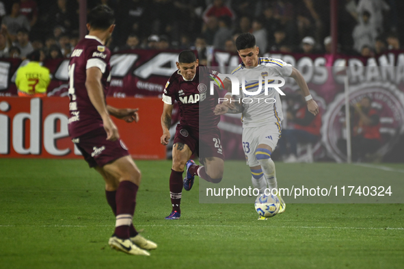 Brian Aguirre of Boca Jrs competes for the ball against Juan Jose Caseres of Lanus during a Liga Profesional 2024 match between Lanus and Bo...