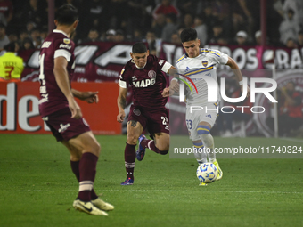 Brian Aguirre of Boca Jrs competes for the ball against Juan Jose Caseres of Lanus during a Liga Profesional 2024 match between Lanus and Bo...