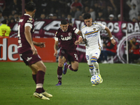 Brian Aguirre of Boca Jrs competes for the ball against Juan Jose Caseres of Lanus during a Liga Profesional 2024 match between Lanus and Bo...