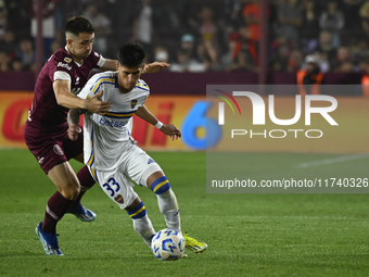 Brian Aguirre of Boca Jrs competes for the ball against Felipe Pena Biafore of Lanus during a Liga Profesional 2024 match between Lanus and...