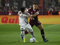 Brian Aguirre of Boca Jrs competes for the ball against Felipe Pena Biafore of Lanus during a Liga Profesional 2024 match between Lanus and...