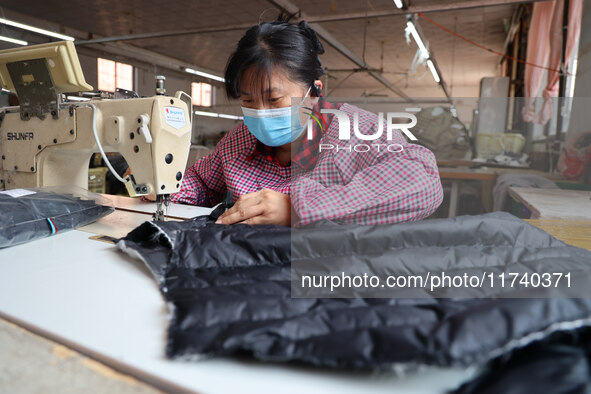 Workers make down jackets at a workshop of a garment manufacturer in Hehe town, Yangxin county, Binzhou city, East China's Shandong province...