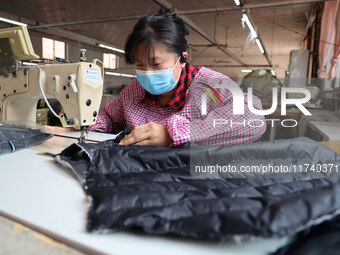 Workers make down jackets at a workshop of a garment manufacturer in Hehe town, Yangxin county, Binzhou city, East China's Shandong province...