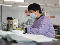 Workers make down jackets at a workshop of a garment manufacturer in Hehe town, Yangxin county, Binzhou city, East China's Shandong province...