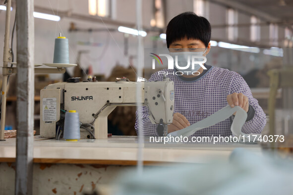 Workers make down jackets at a workshop of a garment manufacturer in Hehe town, Yangxin county, Binzhou city, East China's Shandong province...