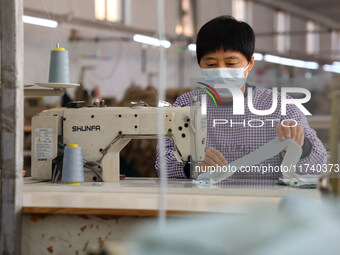 Workers make down jackets at a workshop of a garment manufacturer in Hehe town, Yangxin county, Binzhou city, East China's Shandong province...