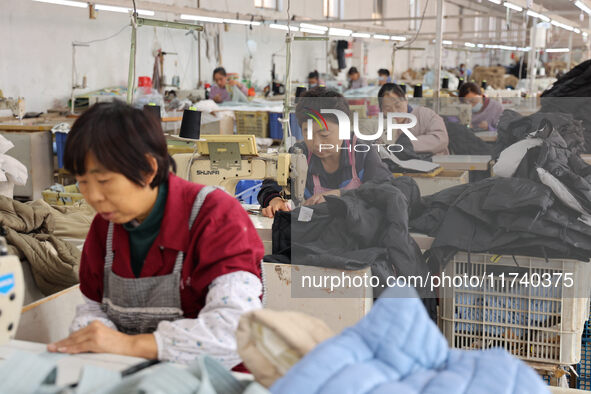 Workers make down jackets at a workshop of a garment manufacturer in Hehe town, Yangxin county, Binzhou city, East China's Shandong province...