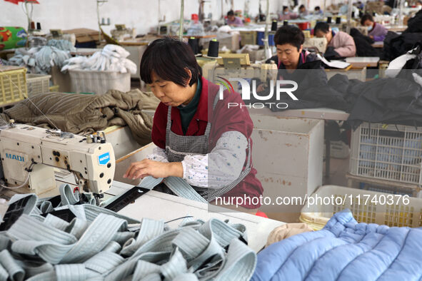 Workers make down jackets at a workshop of a garment manufacturer in Hehe town, Yangxin county, Binzhou city, East China's Shandong province...