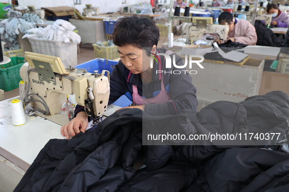 Workers make down jackets at a workshop of a garment manufacturer in Hehe town, Yangxin county, Binzhou city, East China's Shandong province...