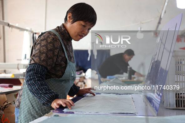 Workers make down jackets at a workshop of a garment manufacturer in Hehe town, Yangxin county, Binzhou city, East China's Shandong province...