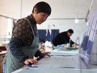 Workers make down jackets at a workshop of a garment manufacturer in Hehe town, Yangxin county, Binzhou city, East China's Shandong province...