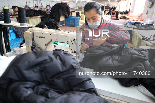 Workers make down jackets at a workshop of a garment manufacturer in Hehe town, Yangxin county, Binzhou city, East China's Shandong province...