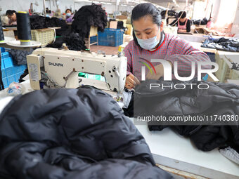 Workers make down jackets at a workshop of a garment manufacturer in Hehe town, Yangxin county, Binzhou city, East China's Shandong province...