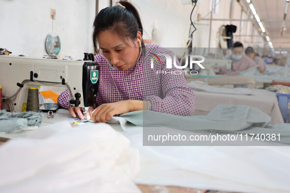 Workers make down jackets at a workshop of a garment manufacturer in Hehe town, Yangxin county, Binzhou city, East China's Shandong province...