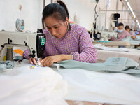 Workers make down jackets at a workshop of a garment manufacturer in Hehe town, Yangxin county, Binzhou city, East China's Shandong province...