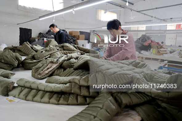 Workers make down jackets at a workshop of a garment manufacturer in Hehe town, Yangxin county, Binzhou city, East China's Shandong province...