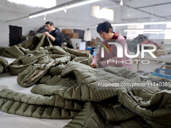 Workers make down jackets at a workshop of a garment manufacturer in Hehe town, Yangxin county, Binzhou city, East China's Shandong province...