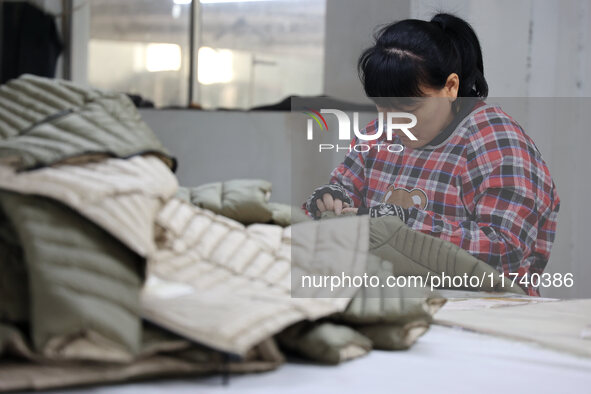 Workers make down jackets at a workshop of a garment manufacturer in Hehe town, Yangxin county, Binzhou city, East China's Shandong province...