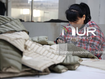 Workers make down jackets at a workshop of a garment manufacturer in Hehe town, Yangxin county, Binzhou city, East China's Shandong province...