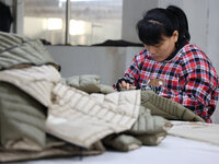 Workers make down jackets at a workshop of a garment manufacturer in Hehe town, Yangxin county, Binzhou city, East China's Shandong province...