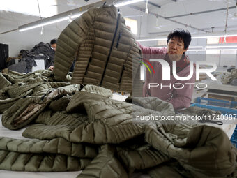 Workers make down jackets at a workshop of a garment manufacturer in Hehe town, Yangxin county, Binzhou city, East China's Shandong province...