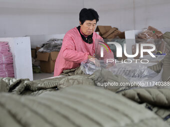 Workers make down jackets at a workshop of a garment manufacturer in Hehe town, Yangxin county, Binzhou city, East China's Shandong province...